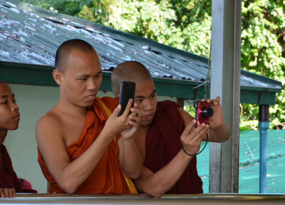 The monks are eager to take photos of the holy snakes and of each other with the snakes